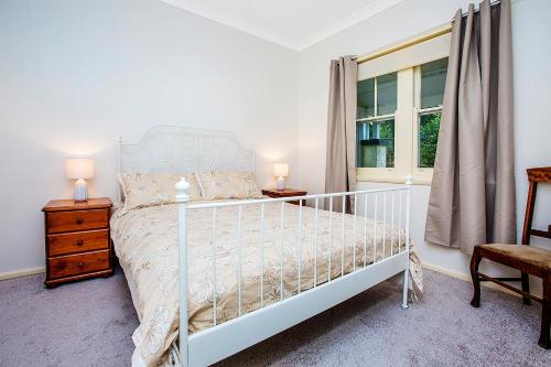 a bedroom with a white bed and a window at Allambee in Katoomba
