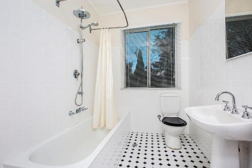 a bathroom with a tub and a toilet and a sink at Allambee in Katoomba