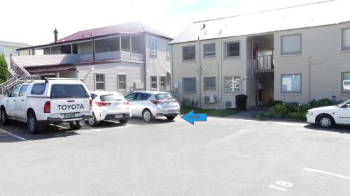a car parked in a parking lot next to a building at Akaroa Vista in Akaroa