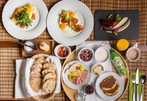 a table with plates of breakfast foods on it at Villa Rosa in Dunajská Streda