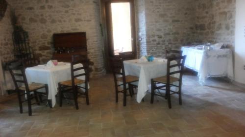 a room with two white tables and chairs and a window at Casale del Monsignore in Spoleto