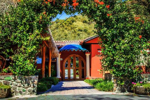 a red house with an archway in front at Regis Hotel Spa in Panajachel