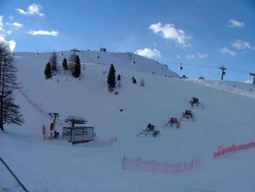 a snow covered slope with people on a ski lift at Hotel Garni Gonzaga in Canazei