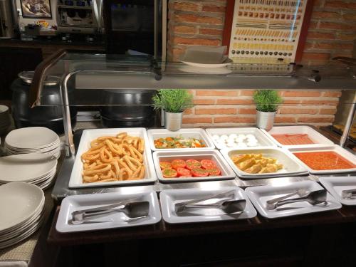 a kitchen with several trays of food on a table at Hotel Telecabina in Sierra Nevada