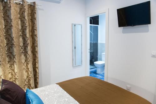 a bedroom with a bed and a bathroom with a toilet at Hotel Fira Boutique Barcelona in Hospitalet de Llobregat