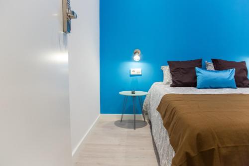 a blue bedroom with a bed and a table at Hotel Fira Boutique Barcelona in Hospitalet de Llobregat
