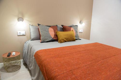 a bedroom with a large bed with colorful pillows at Hotel Fira Boutique Barcelona in Hospitalet de Llobregat