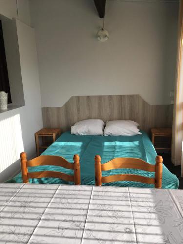 une chambre avec un lit avec une couette verte dans l'établissement Studio Hameau au soleil, à Plage dʼArgelès