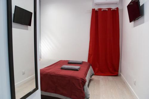 a room with a bed with a red curtain and a mirror at Hotel Fira Boutique Barcelona in Hospitalet de Llobregat