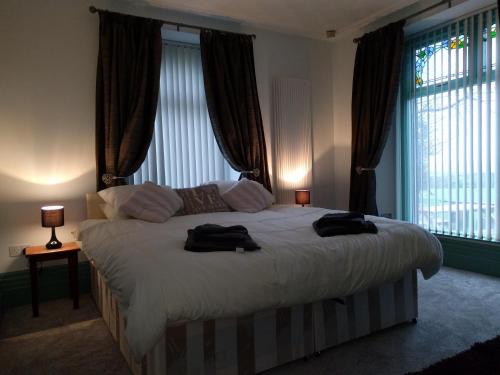1 dormitorio con 1 cama con 2 toallas en The Old Rectory en Amlwch