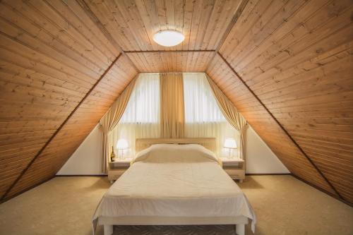 um quarto grande com uma cama num tecto de madeira em Эко Отель Альпийская Долина em Malorechenskoye