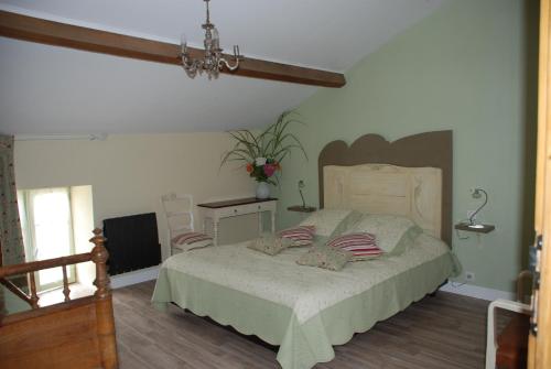 a bedroom with a large bed and a chandelier at Chambres d'Hôtes du Clos Semper Felix in Sainte-Bazeille