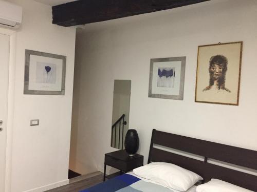 伊索拉德利里的住宿－Waterfall Vicolo V，卧室配有一张床,墙上挂有图片