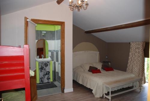 a bedroom with a bed with red pillows on it at Chambres d'Hôtes du Clos Semper Felix in Sainte-Bazeille
