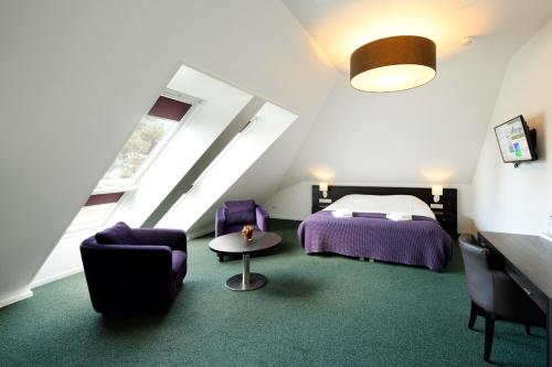 a bedroom with a bed and a table and chairs at Hotel restaurant Nederheide in Milheeze