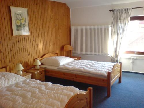 ブットヤーディンゲンにあるZur Kajüteのベッド2台と窓が備わるホテルルームです。