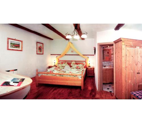 a bedroom with a large bed in a room at Weingut Bohrn Himmelbett in Herrnbaumgarten