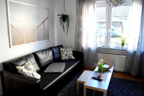 sala de estar con sofá de cuero negro y mesa en Apartment Unna-Massen, en Unna