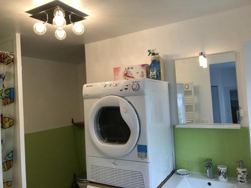 - un lave-linge dans la salle de bains pourvue d'un miroir dans l'établissement Gîte La Croix La grise, à Cherrueix