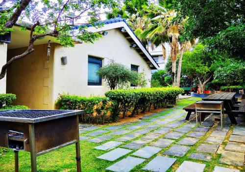 a garden with a table and a bench and a house at Borabora B&B in Nanwan