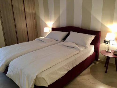 um quarto com uma cama grande e 2 almofadas brancas em apartment Zagara - Gardone Riviera center em Gardone Riviera