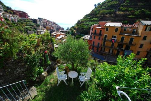 a patio with a table and chairs and buildings at Casa Di Mezzo by Arbaspàa in Manarola