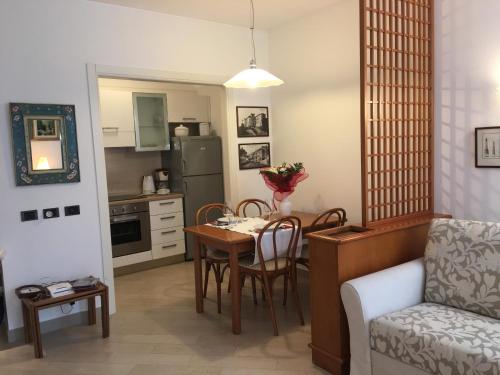 a kitchen and living room with a table and a chair at apartment Zagara - Gardone Riviera center in Gardone Riviera
