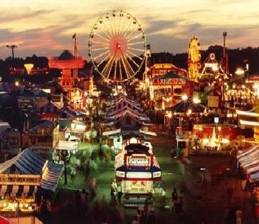a carnival with a ferris wheel and a city at Red Carpet Inn Orchard Park in Orchard Park