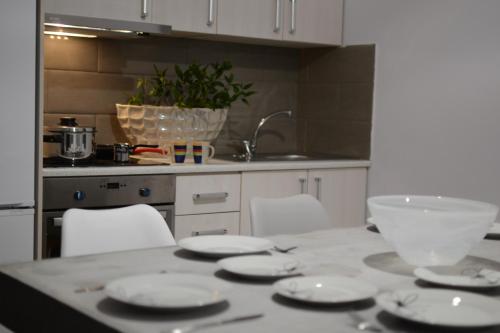 a kitchen with a table with plates and a bowl on it at Green Point Home Chios in Vrontados