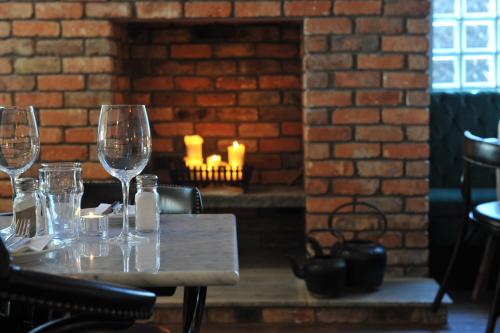 una mesa con copas de vino y una chimenea de ladrillo en The Driftwood, en Sligo