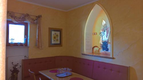a dining room with a table and a painting on the wall at Gasthof Ulrich Meyer in Landshut