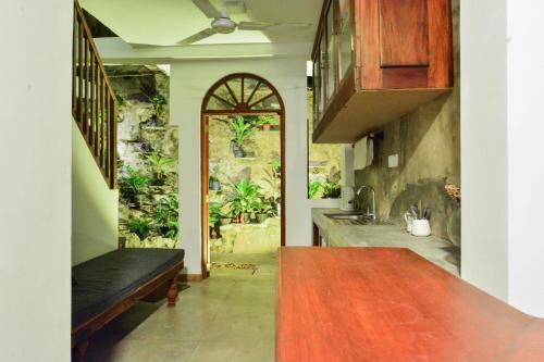 a kitchen with a table and a bench in a room at Fort Sapphire in Galle