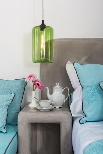 a table with a tea pot and flowers on a couch at Elements of Caldera Suites in Akrotiri