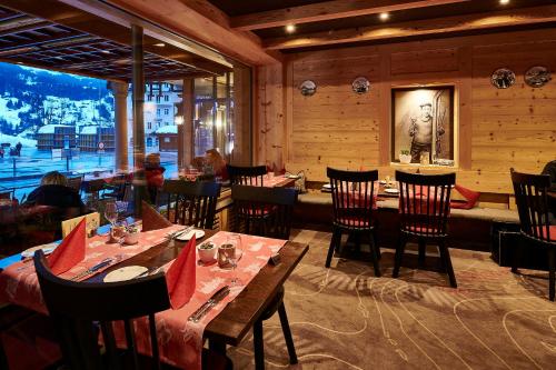 un restaurante con mesas y sillas y una gran ventana en Hotel Central Wolter - Grindelwald, en Grindelwald