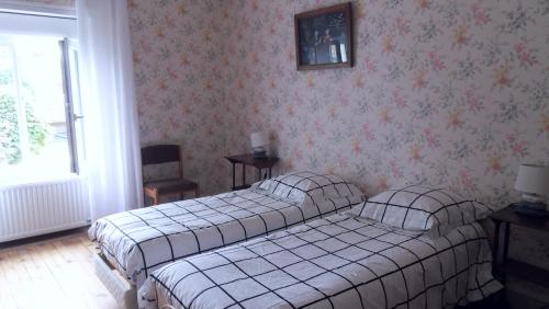 Un pat sau paturi într-o cameră la Maison restaurée - bien ensoleillée - calme