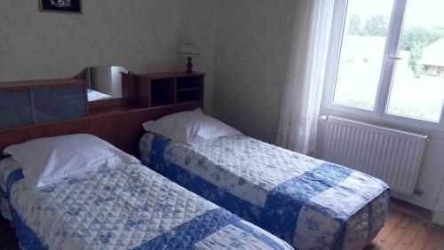 a bedroom with two beds and a mirror and a window at Maison restaurée - bien ensoleillée - calme in Anché