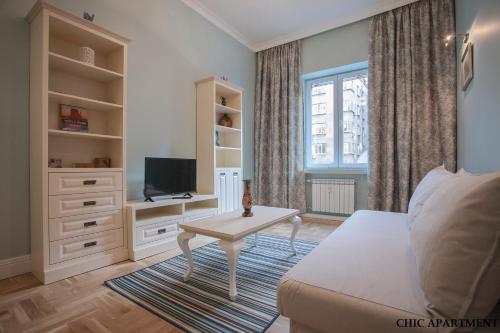 Una sala de estar con una cama, un televisor y una mesa. en Presidency House Self Check-in Apartments, en Sofía