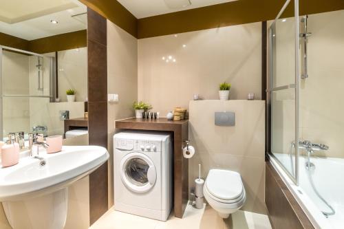 a bathroom with a washing machine and a sink at FriendHouse Apartments in Krakow