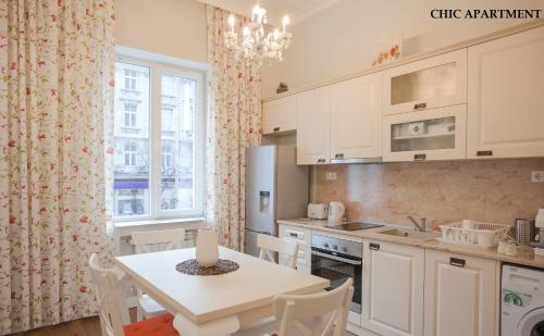 een keuken met een witte tafel en een tafel en stoelen bij Presidency House Self Check-in Apartments in Sofia