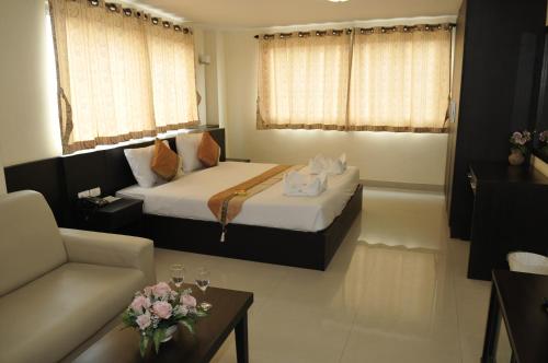 a hotel room with a bed and a couch at Regent Suvarnabhumi Hotel in Lat Krabang