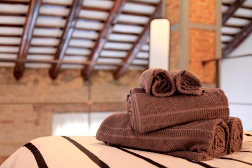 una pila de toallas sentadas encima de una cama en Atico Loft Ruzafa, en Valencia