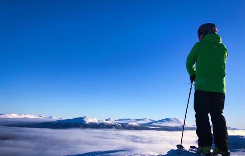 a person on skis standing on top of a mountain at Lemonsjøen-Jotunheimen-Besseggen in Stuttgongfossen