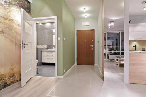 ein Badezimmer mit grünen Wänden und einer braunen Tür in der Unterkunft Strict center Towarowa in Posen
