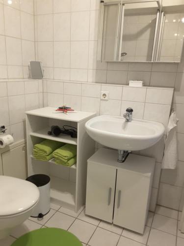 uma casa de banho branca com um lavatório e um WC em Citywohnung am Rannischen Platz II em Halle an der Saale