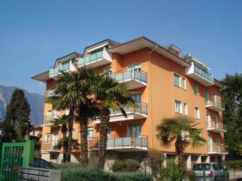 a building with palm trees in front of it at Boschetto in Riva del Garda
