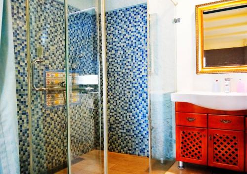 a bathroom with a glass shower and a sink at Borabora B&B in Nanwan