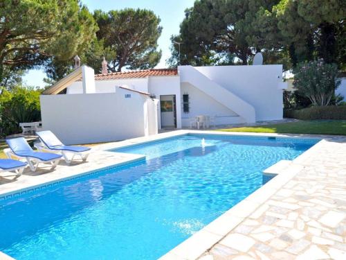 ヴィラモウラにあるCharming villa in Vilamoura with private poolのスイミングプール(椅子付)と家