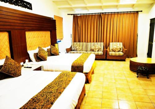 a hotel room with two beds and two chairs at Borabora B&B in Nanwan