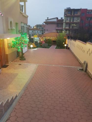 a red brick walkway with a tree in the middle at Family Hotel Kedara in Burgas City