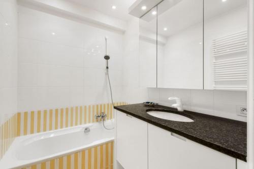 uma casa de banho com um lavatório e uma banheira em Apartment Entre Ciel et Mer em Knokke-Heist